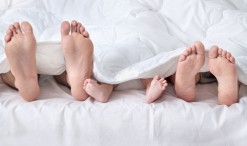 34580064 - feet of a family sticking out from the quilt
